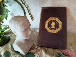 The book in which Frances Ida Jones's phrenology reading was recorded and the phrenology bust.